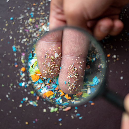 Magnifying microplastics on fingers