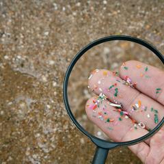 microscope over microplastics on hand